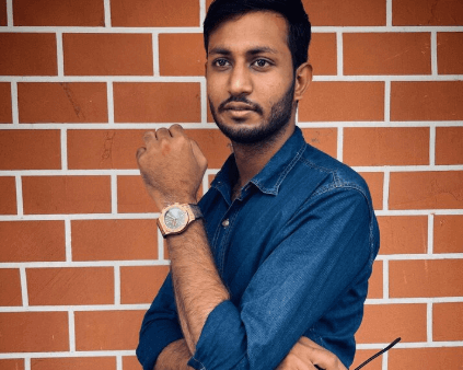 Adult man standing against a brick wall