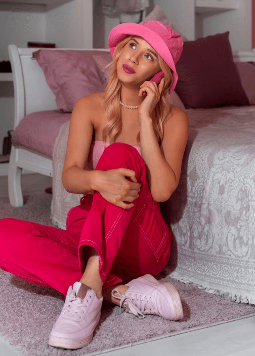 Adult woman in a pink hat sitting in a softly lit room
